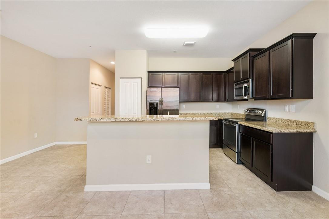 710 Southwest 1st Way Pompano Beach, FL 33060 - Photo 18 of 38 a kitchen with stainless steel appliances granite countertop a stove top oven a sink and dishwasher