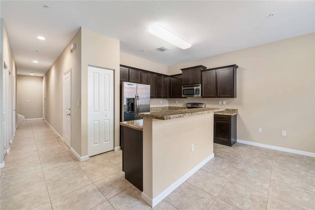 710 Southwest 1st Way Pompano Beach, FL 33060 - Photo 19 of 38 a kitchen with kitchen island a refrigerator stove and microwave