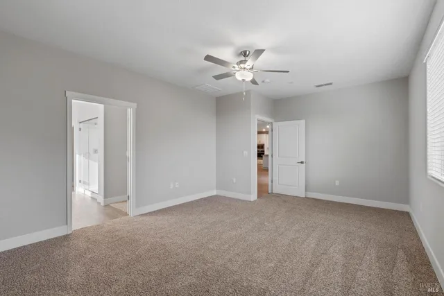a view of an empty room with a ceiling fan
