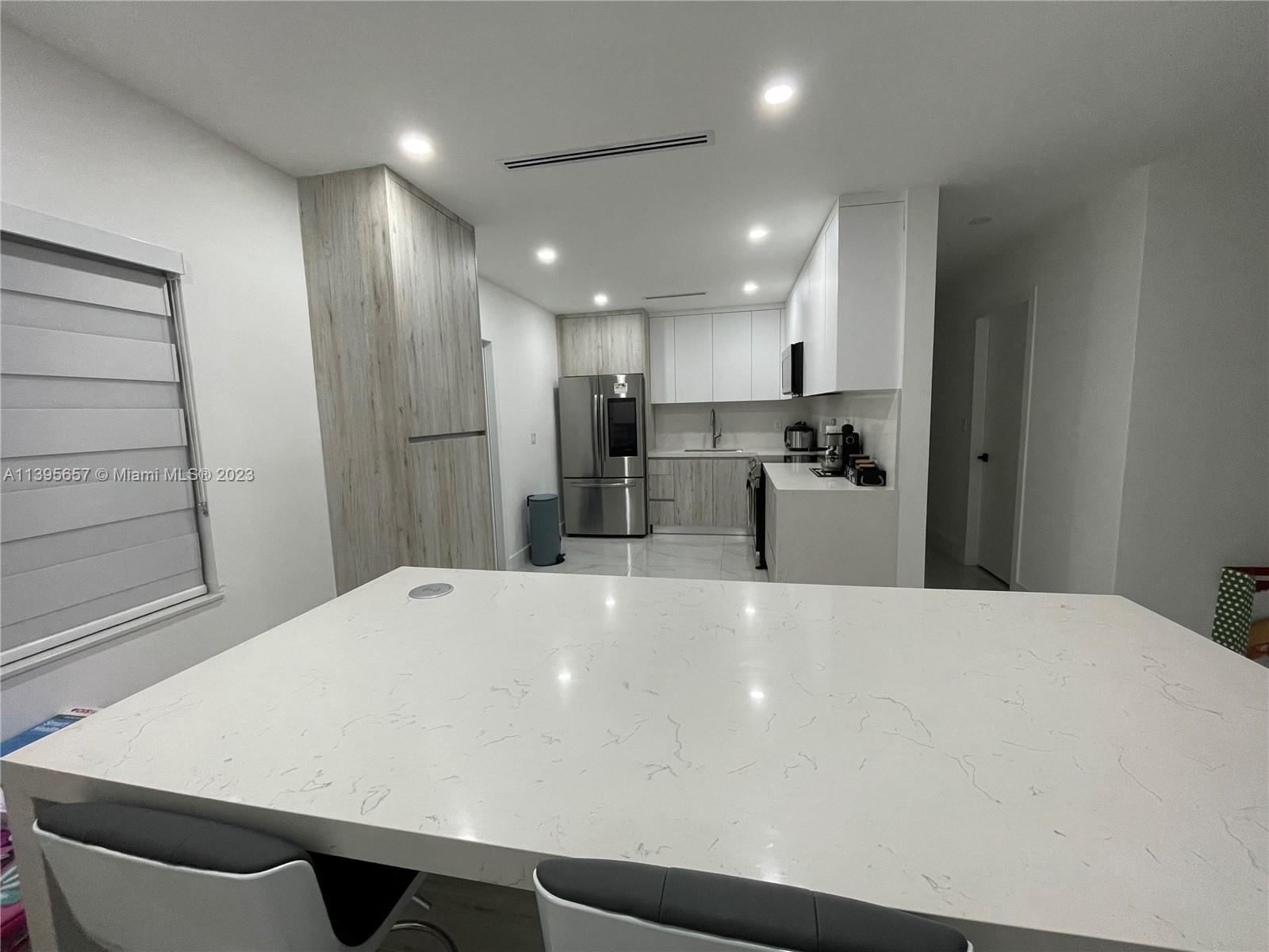 685 East 9th Lane Hialeah, FL 33010 - Photo 23 of 47 a large white kitchen with a refrigerator a sink and a stove