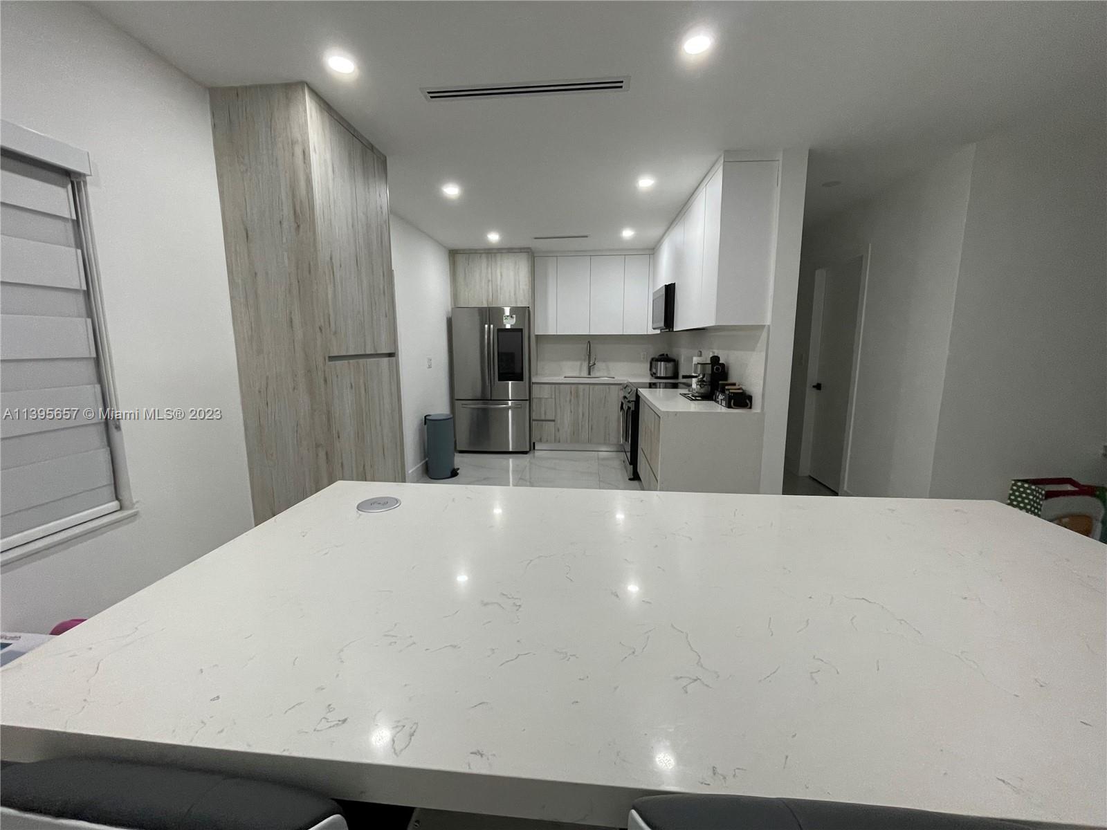 685 East 9th Lane Hialeah, FL 33010 - Photo 24 of 47 a large white kitchen with a refrigerator a stove a sink and white cabinets