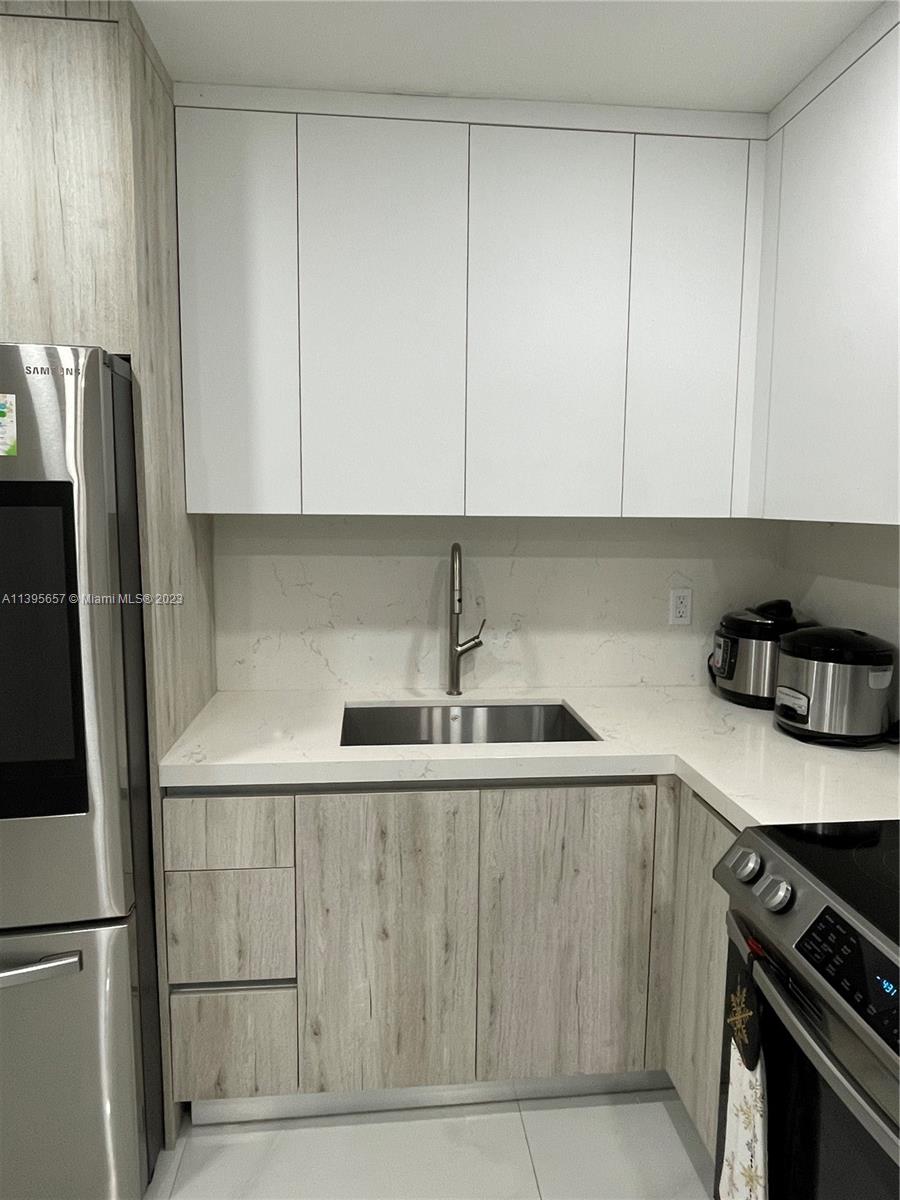 685 East 9th Lane Hialeah, FL 33010 - Photo 27 of 47 a kitchen with stainless steel appliances granite countertop a sink stove and refrigerator