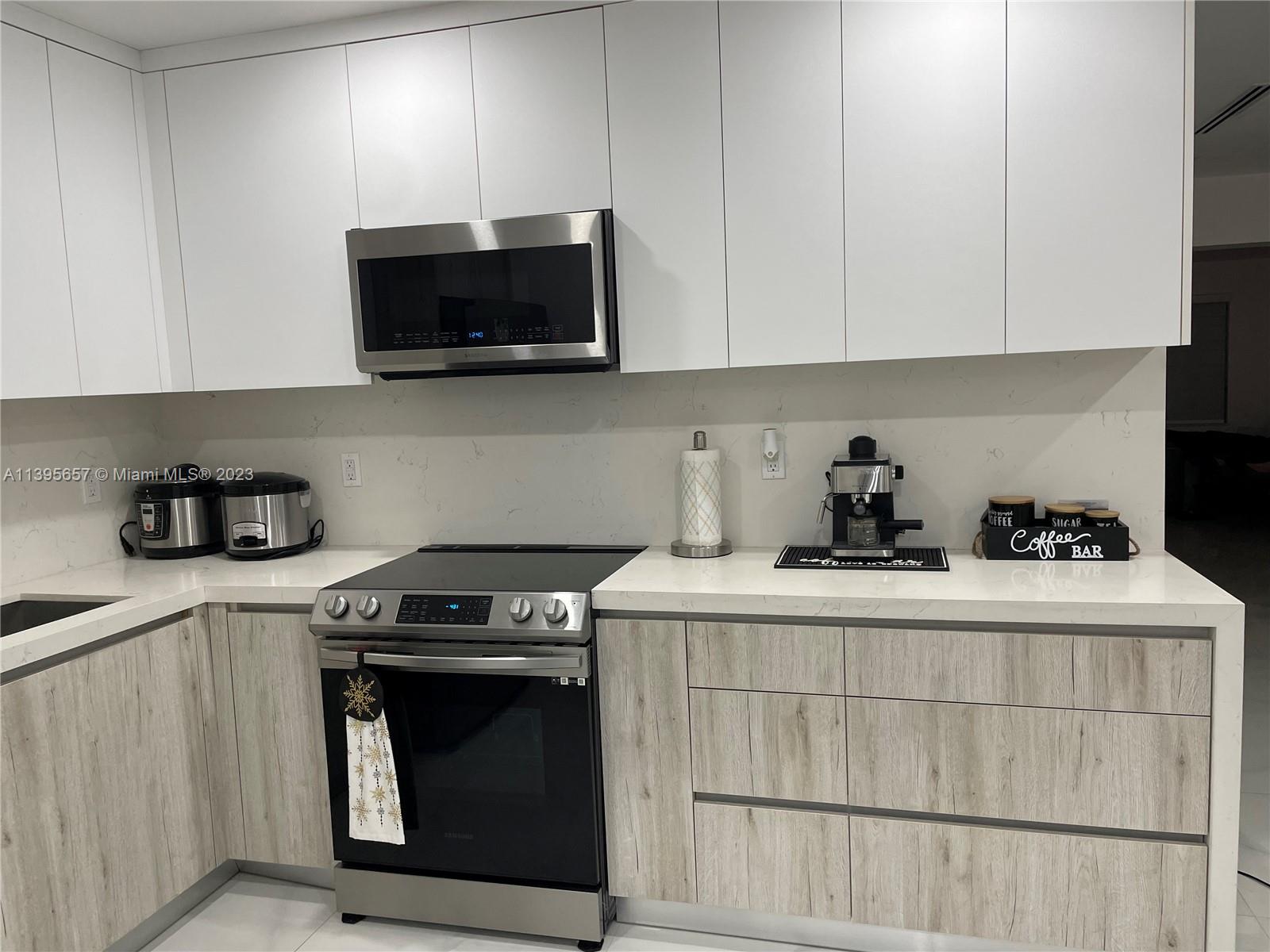 685 East 9th Lane Hialeah, FL 33010 - Photo 29 of 47 a kitchen with stainless steel appliances a stove a microwave and cabinets