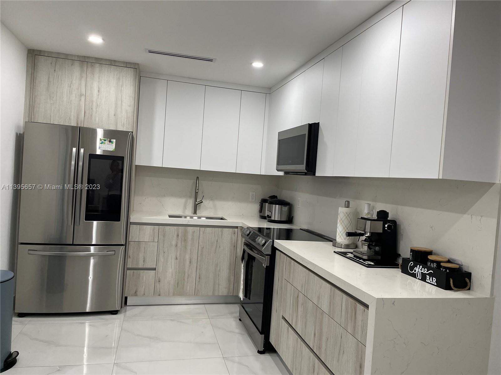 685 East 9th Lane Hialeah, FL 33010 - Photo 30 of 47 a kitchen with a sink a refrigerator and cabinets
