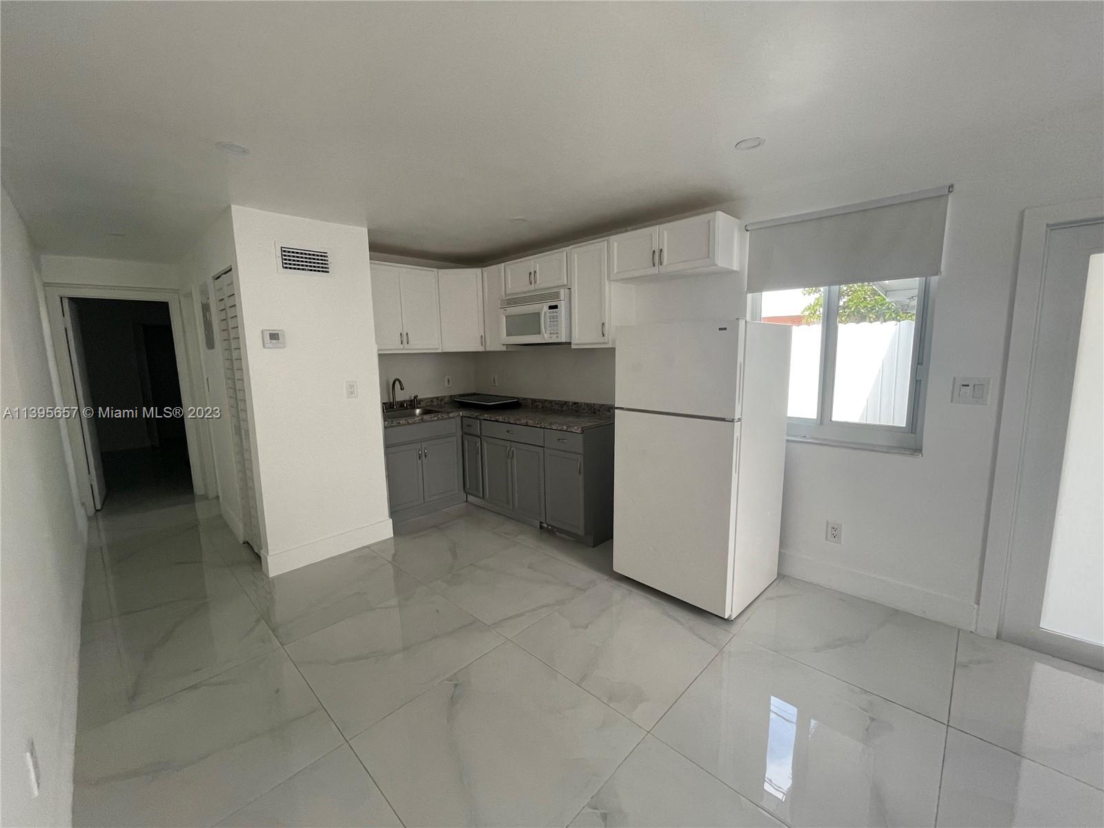 685 East 9th Lane Hialeah, FL 33010 - Photo 8 of 47 a kitchen with a refrigerator a microwave and cabinets