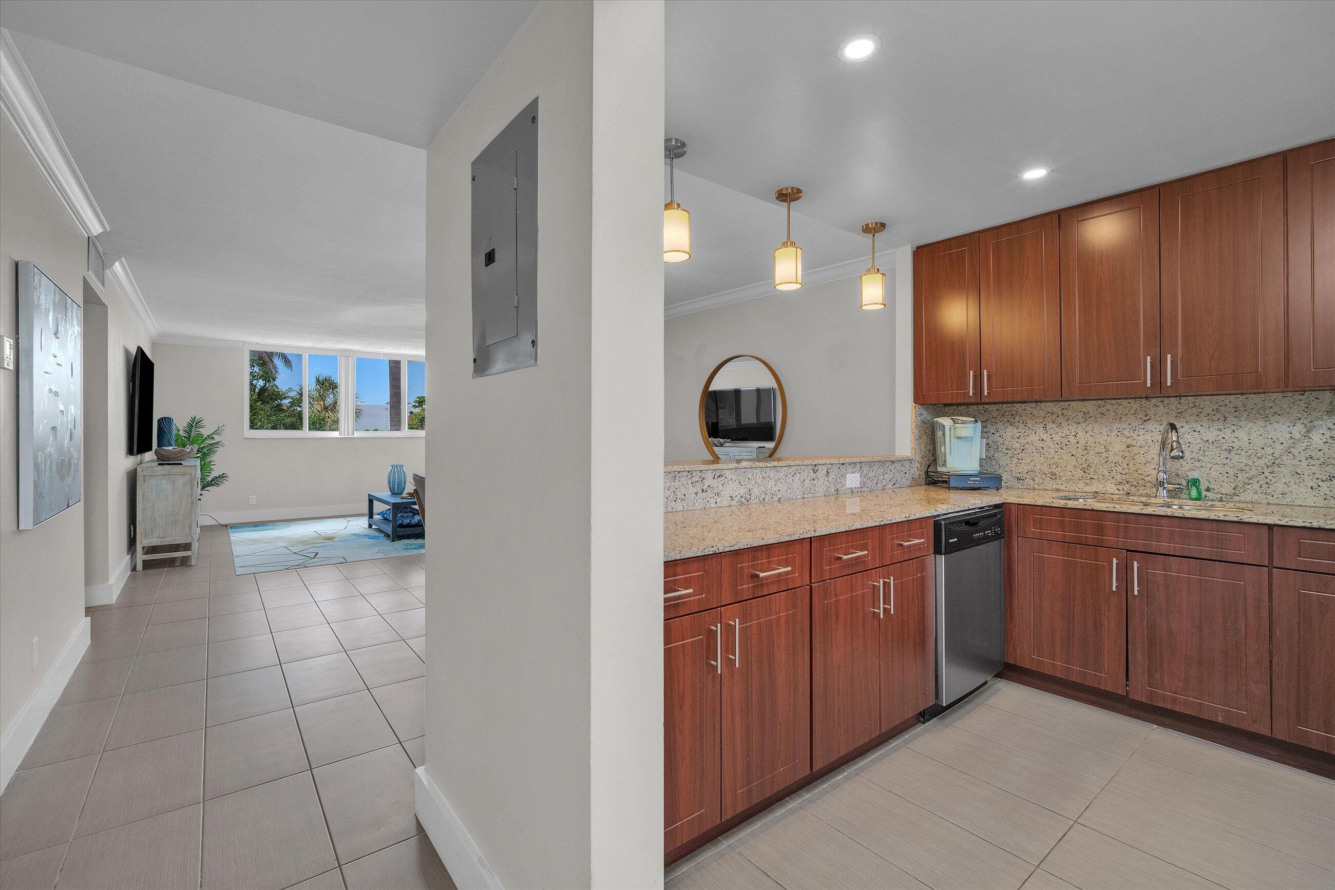 601 North Ocean Boulevard, Unit 203 Boca Raton, FL 33432 - Photo 3 of 20 a large kitchen with stainless steel appliances granite countertop a sink and cabinets