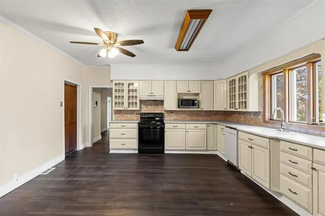 a kitchen with granite countertop white cabinets and white appliances