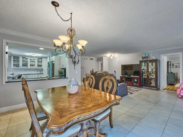 a dining room filled chandelier and wooden floor
