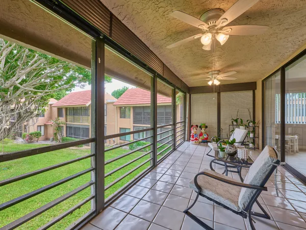 a living room with patio furniture and a floor to ceiling window