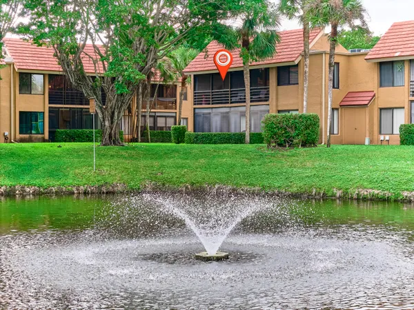 a front view of a house with a yard and lake view
