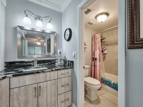 a bathroom with a granite countertop sink mirror vanity and toilet
