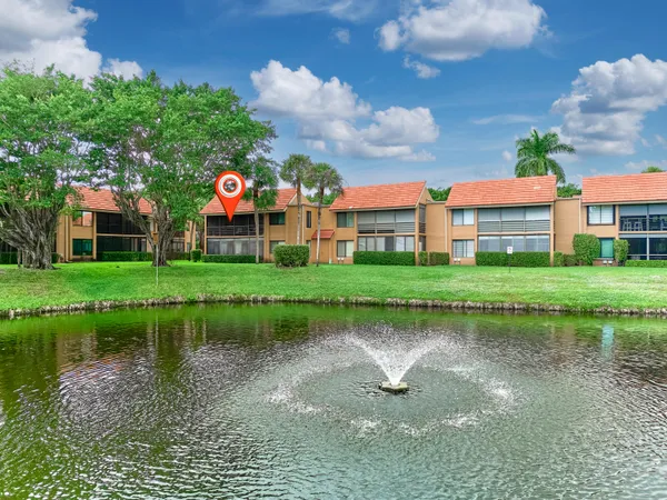 a view of a lake with a big yard and potted plants