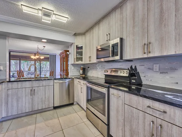 a kitchen with stainless steel appliances granite countertop a sink and a stove