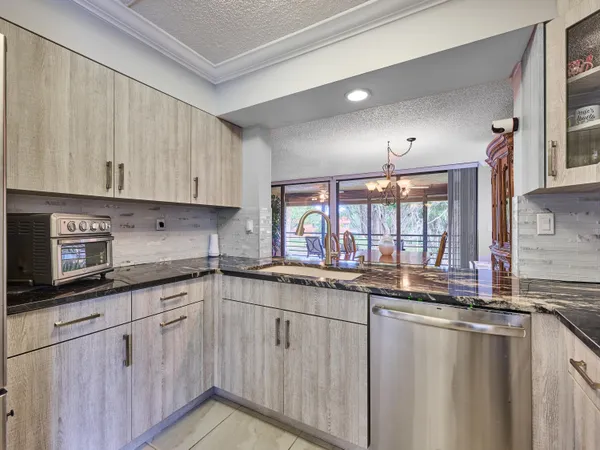 a kitchen with granite countertop a sink and a stove top oven