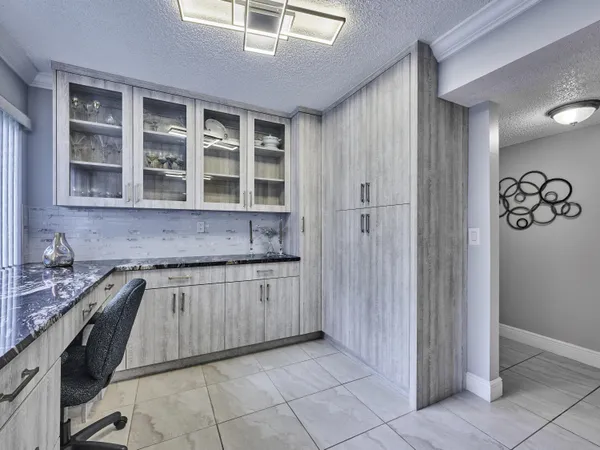 a kitchen with granite countertop a sink stove and cabinets