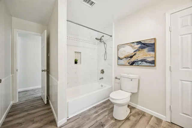 a bathroom with a toilet and a shower