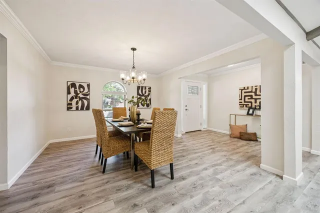 a view of a dining room with furniture and chandelier