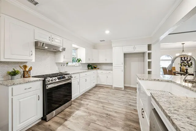 a large kitchen with stainless steel appliances granite countertop a stove and a sink