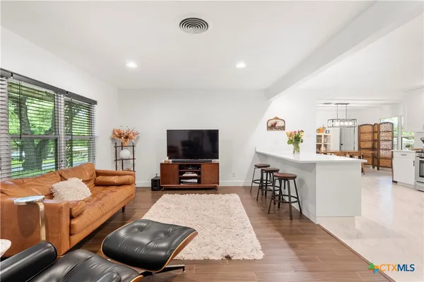 a living room with furniture a flat screen tv and a large window