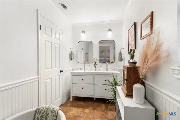 a spacious bathroom with a double vanity sink mirror and bathtub
