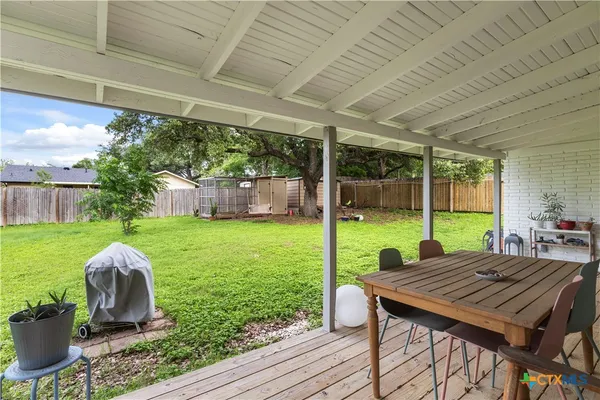 a view of a backyard with table and chairs potted plants with wooden floor