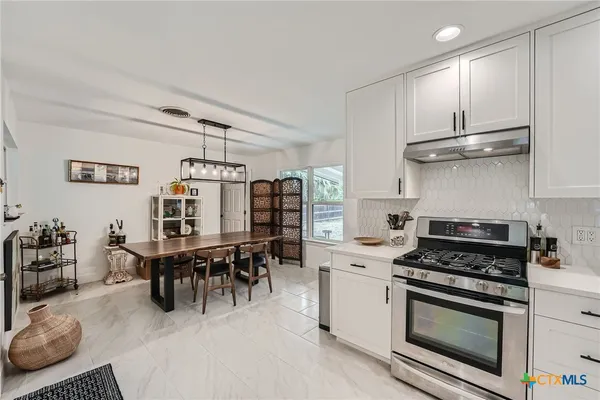 a kitchen with stainless steel appliances granite countertop a stove and a refrigerator