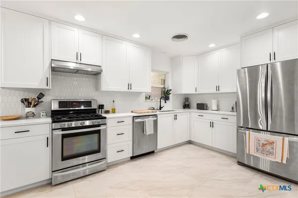 a kitchen with a stove sink and refrigerator