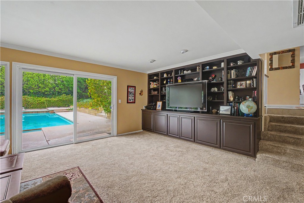 22671 Town Crier Road Calabasas, CA 91302 - Photo 17 of 35 a living room with a flat screen tv and floor to ceiling window