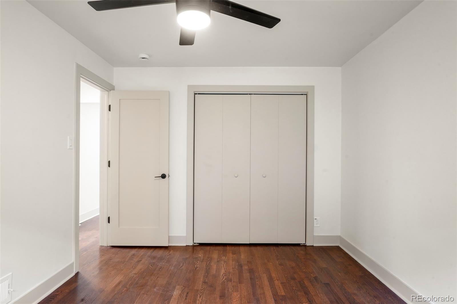 809 Forest Street Denver, CO 80220 - Photo 12 of 15 an empty room with wooden floor and windows