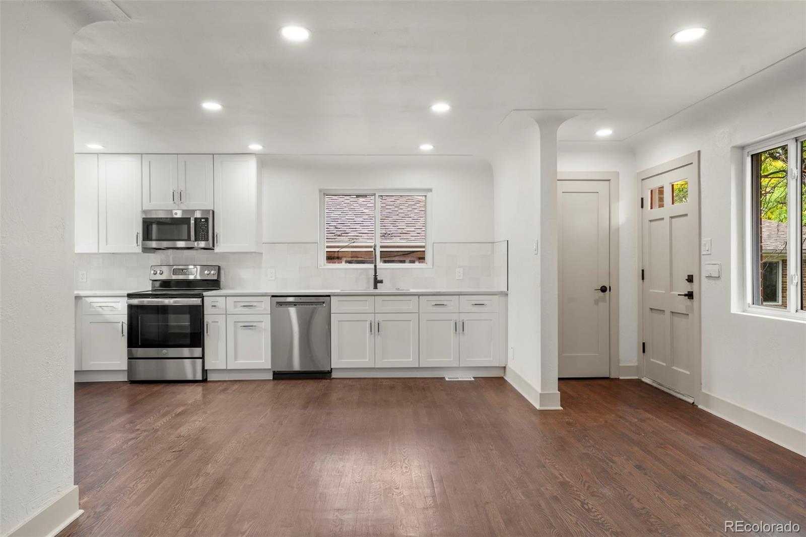 809 Forest Street Denver, CO 80220 - Photo 4 of 15 a kitchen with stainless steel appliances a refrigerator and a stove top oven
