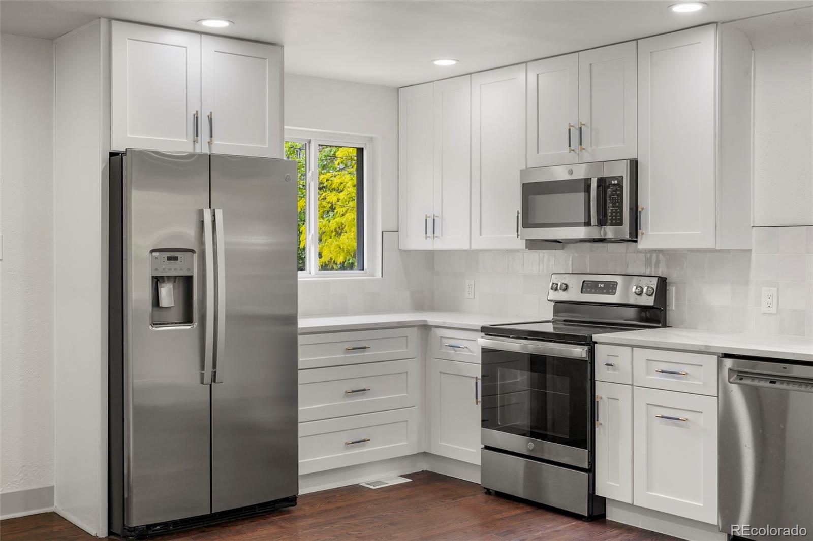 809 Forest Street Denver, CO 80220 - Photo 5 of 15 a kitchen with cabinets stainless steel appliances and a window