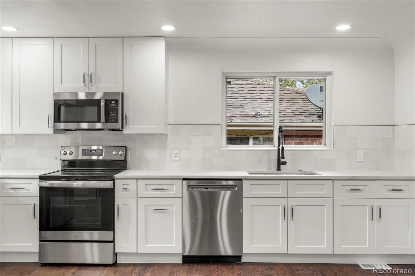 809 Forest Street Denver, CO 80220 - Photo 6 of 15 a kitchen with stainless steel appliances granite countertop a stove a sink and a microwave