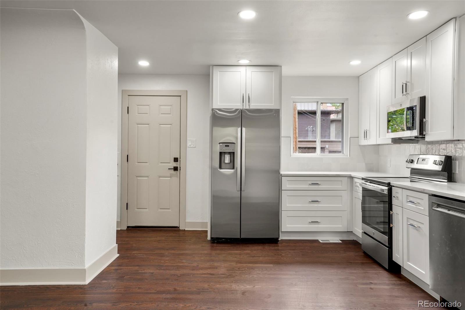 809 Forest Street Denver, CO 80220 - Photo 7 of 15 a kitchen with stainless steel appliances a refrigerator and a stove top oven