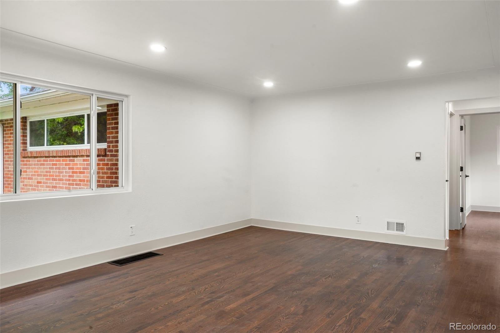 809 Forest Street Denver, CO 80220 - Photo 8 of 15 wooden floor in an empty room with a window