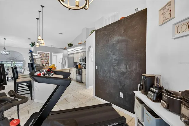 a kitchen with stainless steel appliances a refrigerator a sink a stove and white cabinets