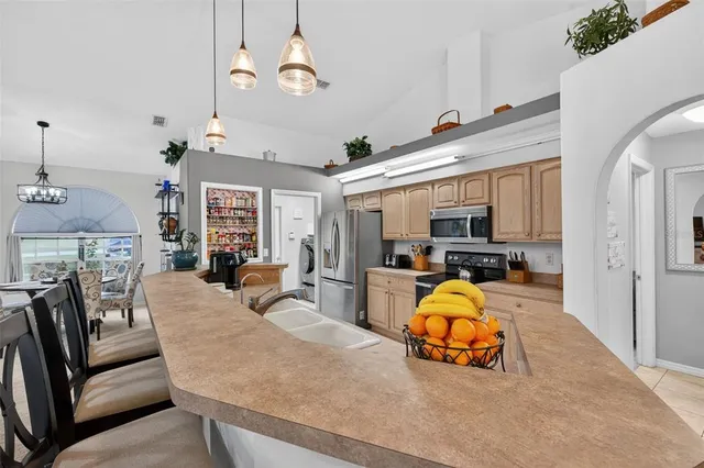 a kitchen with stainless steel appliances kitchen island granite countertop a sink a stove and a refrigerator