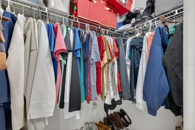 a bed sitting in a bedroom next to a window and a chandelier