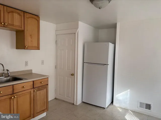 a kitchen with cabinets and a refrigerator