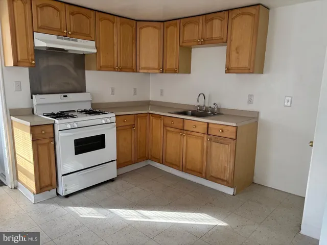 a kitchen with granite countertop a stove sink and cabinets
