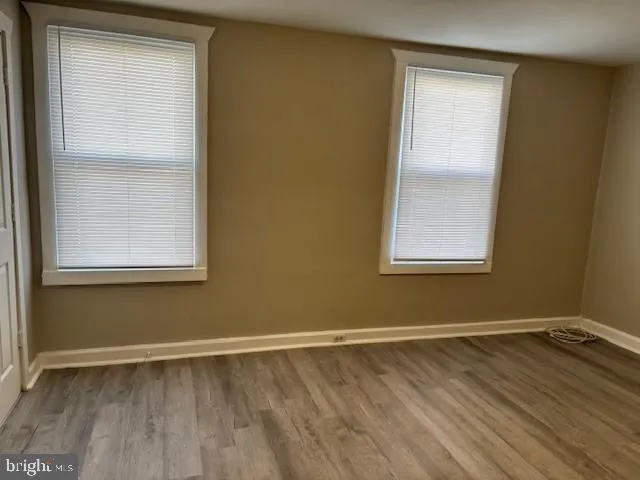 a view of a room with wooden floor and windows