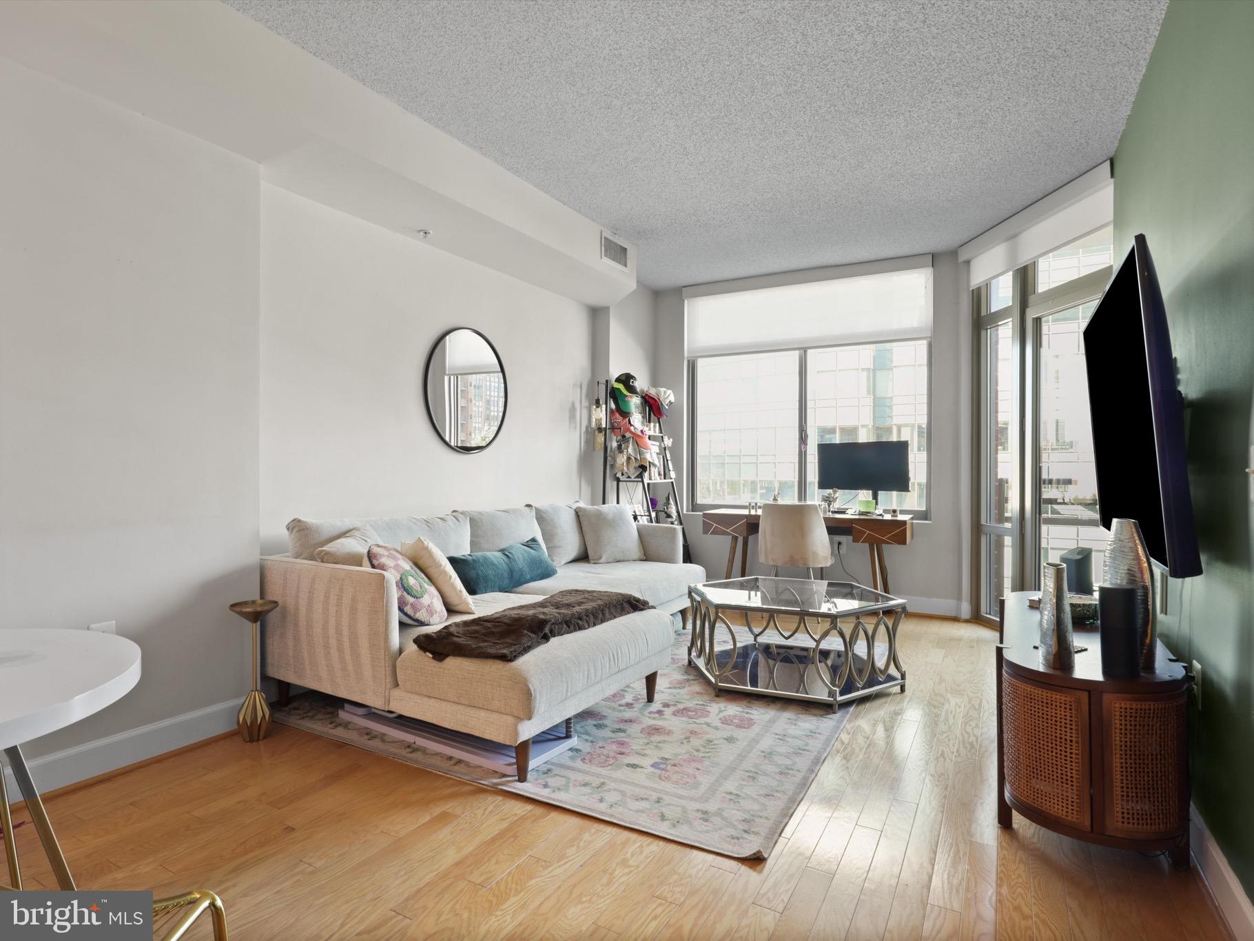 a living room with furniture a flat screen tv and a large window