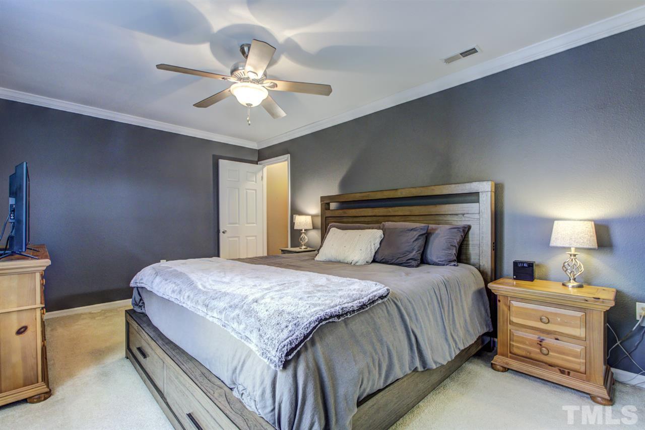 7625 Falcon Rest Circle, Unit 7625 Raleigh, NC 27615 - Photo 15 of 29 a bedroom with a bed and a chandelier