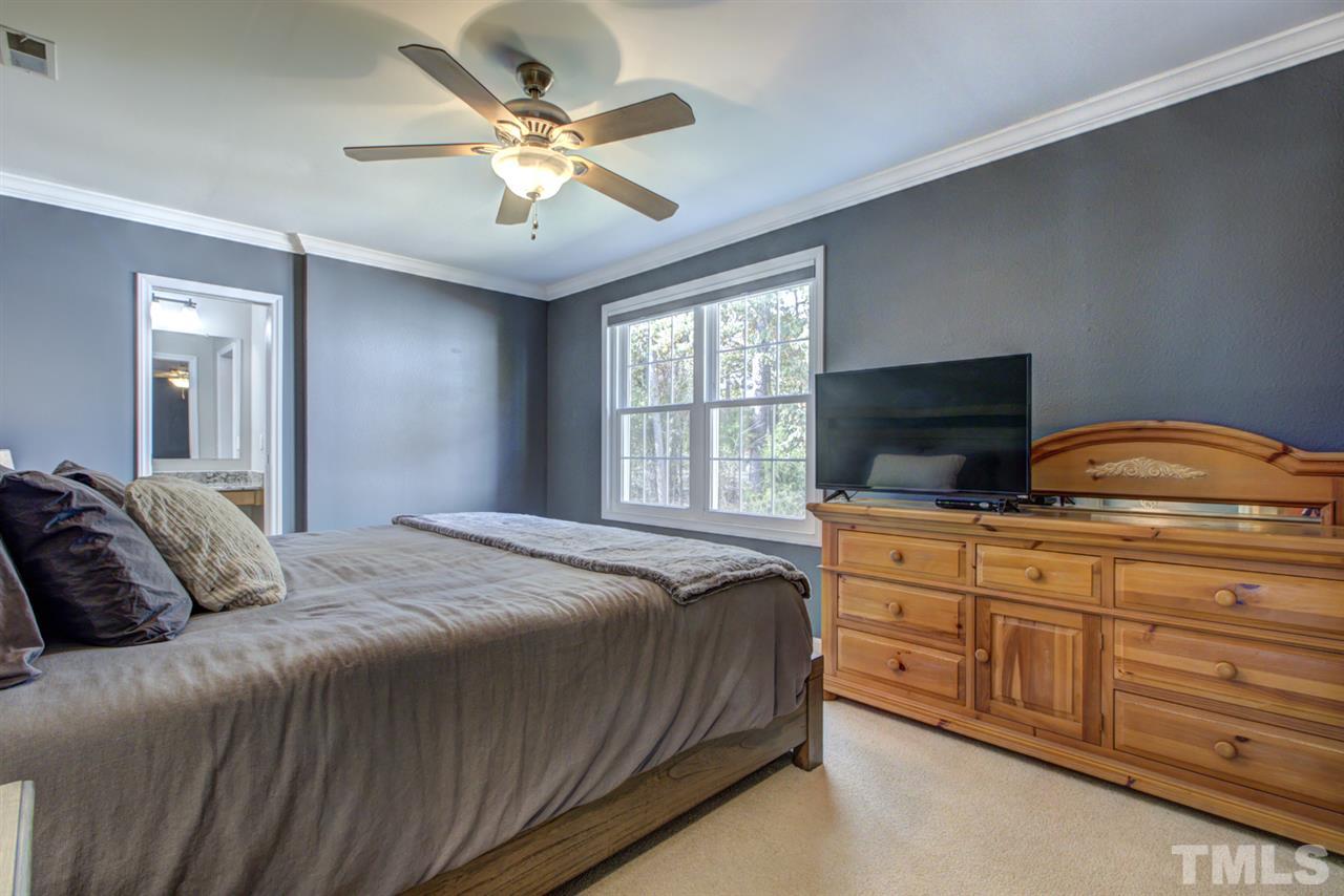 7625 Falcon Rest Circle, Unit 7625 Raleigh, NC 27615 - Photo 16 of 29 a bedroom with a large bed and ceiling fan