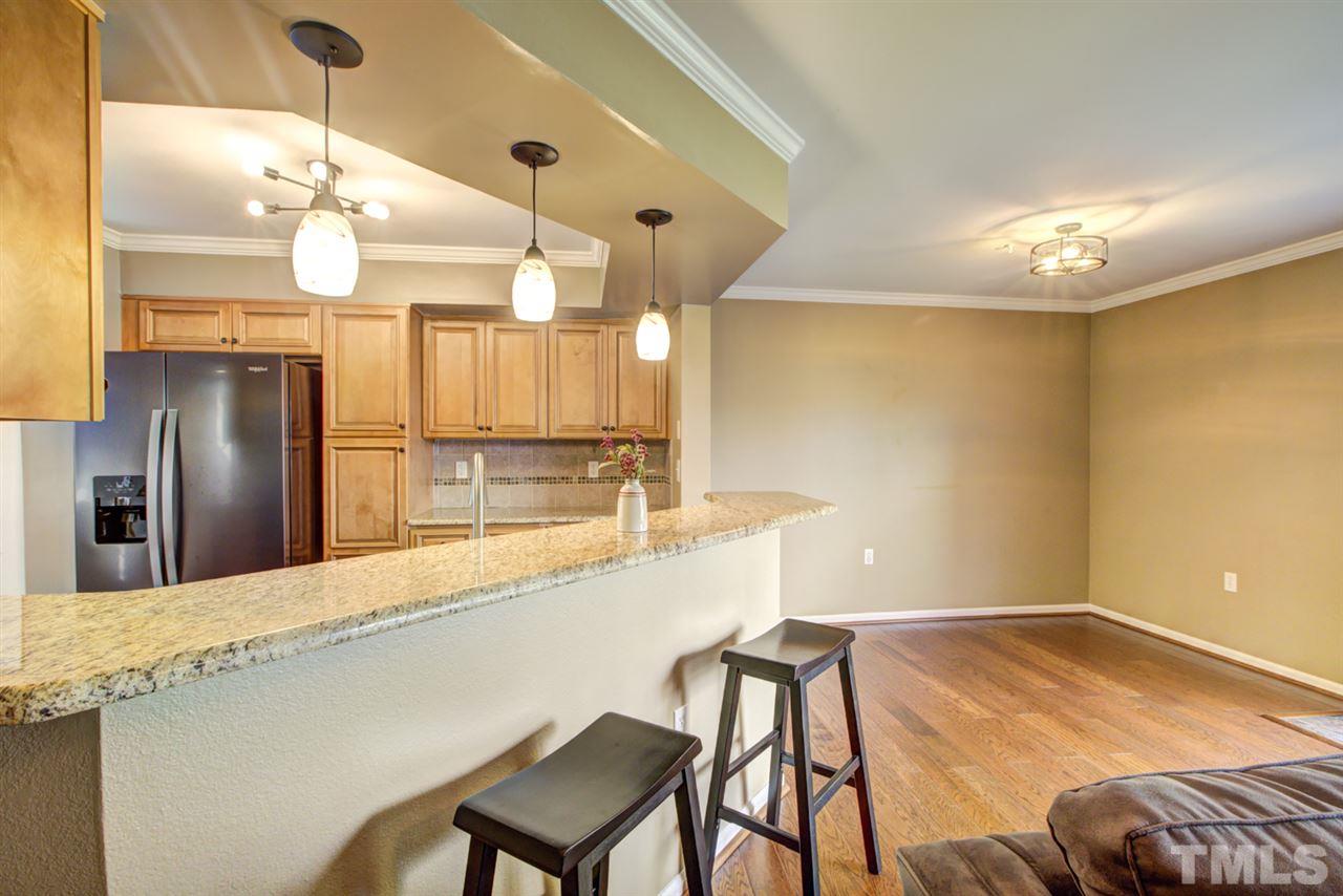 7625 Falcon Rest Circle, Unit 7625 Raleigh, NC 27615 - Photo 8 of 29 a kitchen with stainless steel appliances kitchen island a chandelier