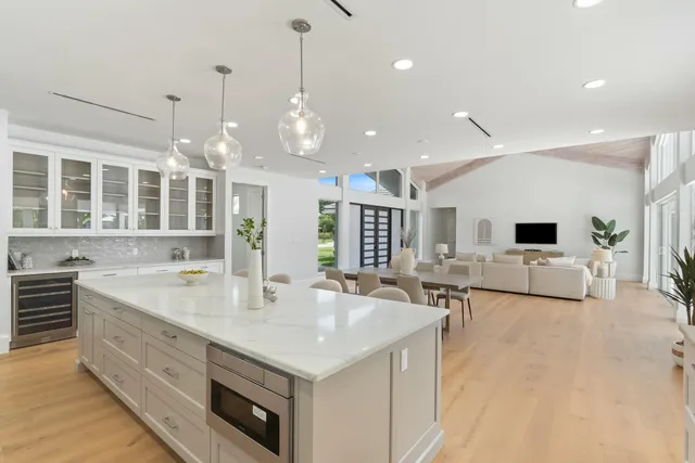 a large white kitchen with a large window and couch