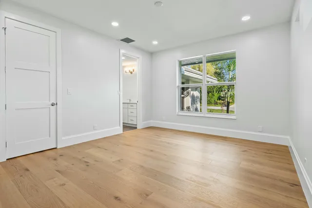 a bathroom with a granite countertop toilet a sink and a mirror