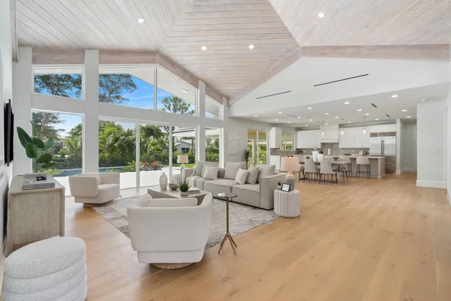 a living room with furniture kitchen view and a large window