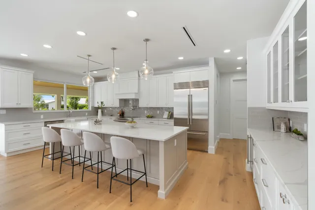 a dining room with stainless steel appliances furniture large window and wooden floor