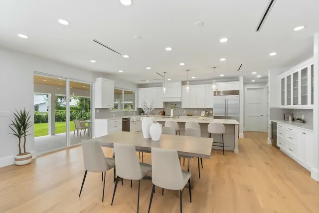 a large kitchen with kitchen island a sink table and chairs