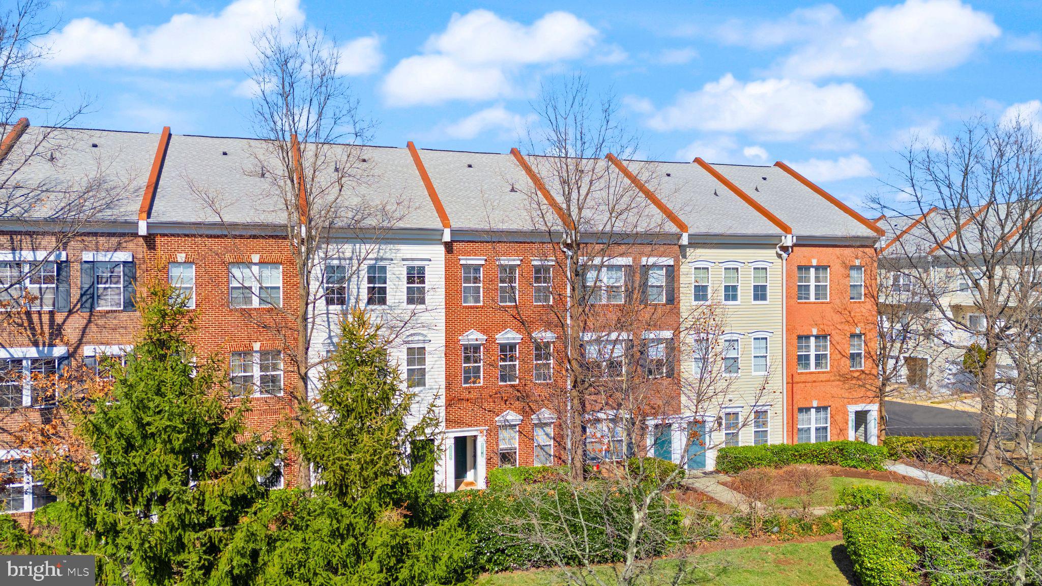 42427 Goldenseal Square Brambleton, VA 20148 - Photo 3 of 52 a view of a large building next to a yard